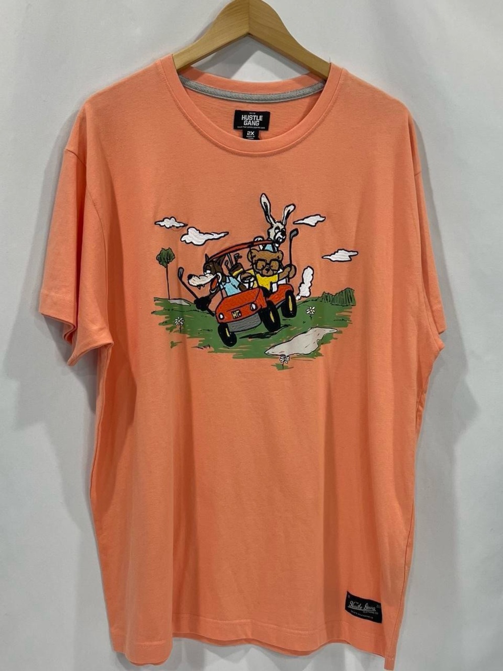 Hustle Gang Peach Short-Sleeve Tee with Cartoon Golf Cart Graphic